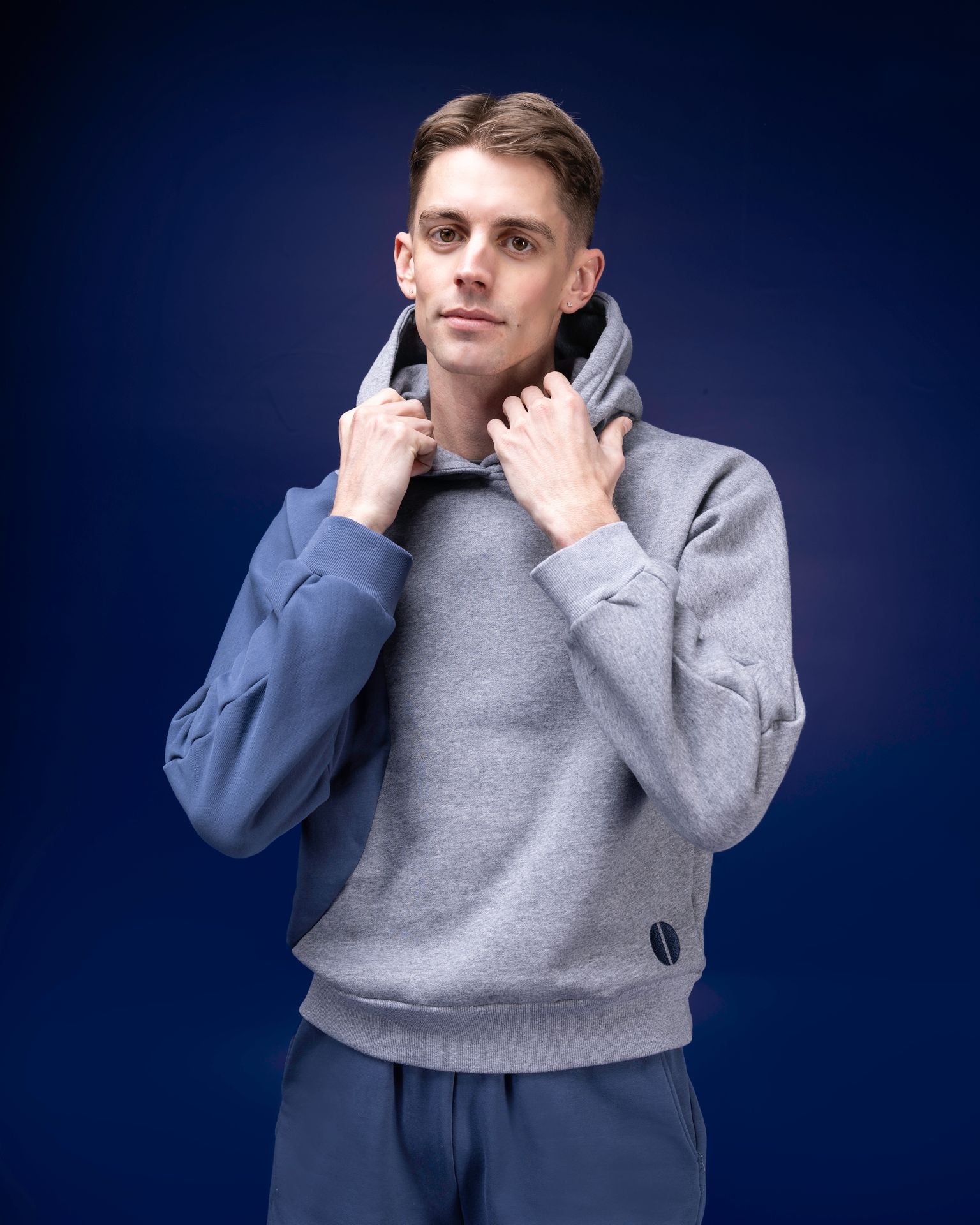 Male dancer wearing male dancewear grey and blue warm up hoodie